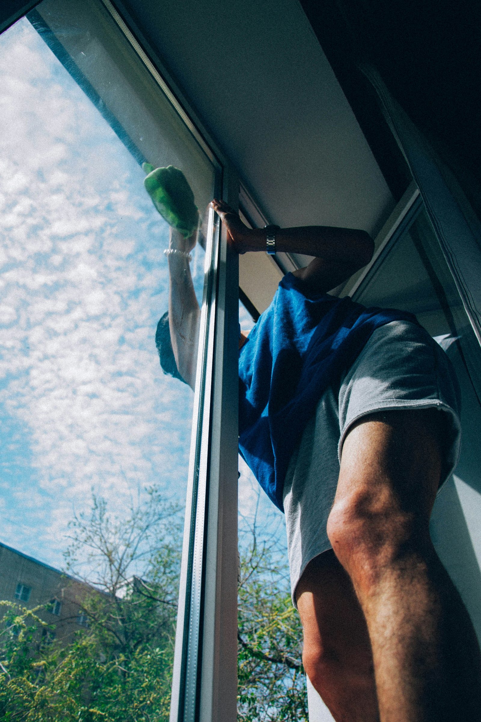 Window being cleaned from the interior, looking out toward the sky and trees